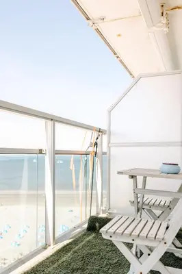 a room with a table and a view of the ocean at Dare to be different in Zandvoort