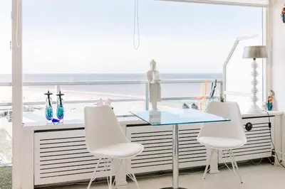 a dining room with a view of the beach at Dare to be different in Zandvoort