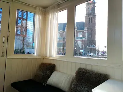 a window seat with a couch and a clock tower at Prince Royal B&B in Amsterdam