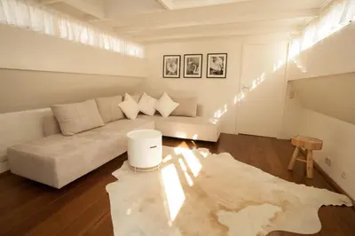 a white living room with a couch and a rug at Prince Royal B&B in Amsterdam