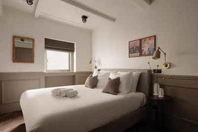 a white bedroom with a large white bed with pillows at Adam Downtown in Amsterdam
