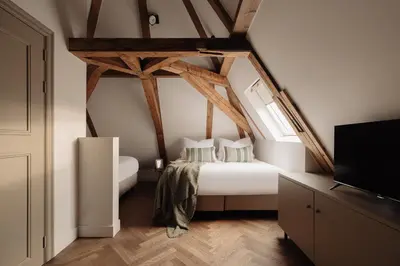 a bedroom with a white bed with wooden beams at Adam Downtown in Amsterdam
