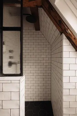 a bathroom with white subway tiles and a window at Adam Downtown in Amsterdam