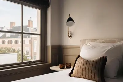a bedroom with a bed and a large window at Adam Downtown in Amsterdam