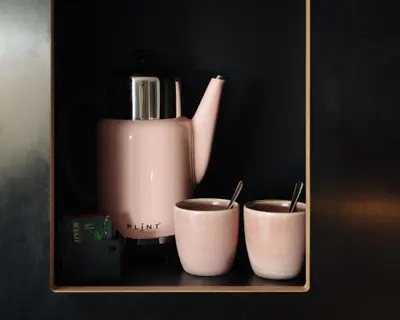 a blender and two cups sitting on a shelf at Conscious Hotel The Tire Station in Amsterdam