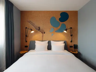 a bedroom with a white bed with lights on it at Conscious Hotel The Tire Station in Amsterdam