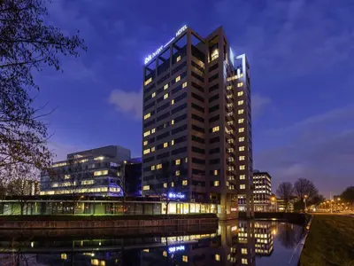 a tall building is lit up at night at ibis budget Amsterdam City South in Amstelveen