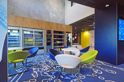 a library with colorful chairs and tables in a room at ibis budget Amsterdam City South in Amstelveen