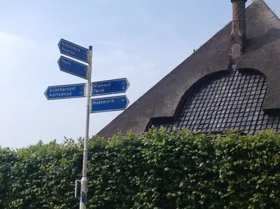 a street sign with blue street signs in front of a building at Chalet Ben in Broek in Benningbroek