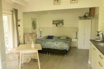 a bedroom with a bed and a table in it at Chalet Ben in Broek in Benningbroek
