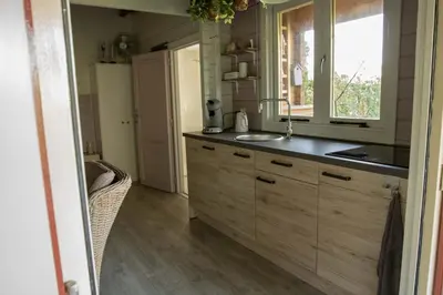 a kitchen with a sink and a window at Chalet Ben in Broek in Benningbroek