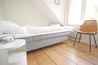 a living room with a couch and a chair at Beautiful 2 floor Vondelpark apartment. in Amsterdam