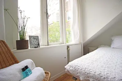 a bedroom with a bed and a window at Beautiful 2 floor Vondelpark apartment. in Amsterdam