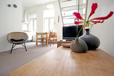 a living room with a vase with flowers on a table at Beautiful 2 floor Vondelpark apartment. in Amsterdam