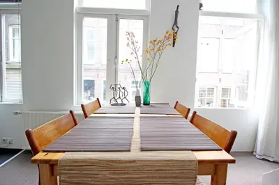 a dining room table with chairs and a vase on it at Beautiful 2 floor Vondelpark apartment. in Amsterdam