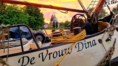 a boat with the words be through docked at Zeilschip De Vrouw Dina in Leiden