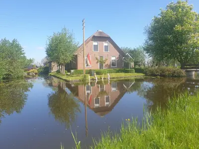 a house with its reflection in the water at Boutique vakantiehuis Het Stalhuys in Reeuwijk