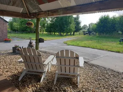 two white chairs sitting under a gazebo at Boutique vakantiehuis Het Stalhuys in Reeuwijk