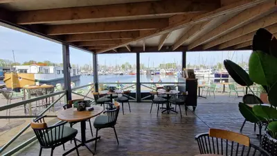 a restaurant with tables and chairs and a marina at Marinaparcs Naarden in Naarden