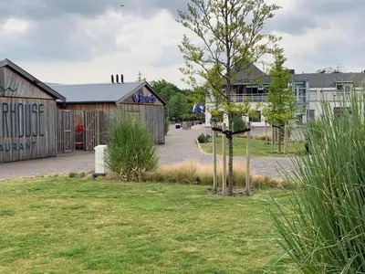 a building with a tree in the middle of a yard at Marinaparcs Naarden in Naarden