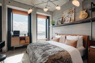 a bedroom with a large bed and a guitar at Sir Adam Hotel, part of Sircle Collection in Amsterdam