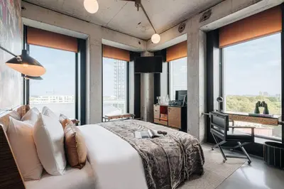 a bedroom with a large bed and large windows at Sir Adam Hotel, part of Sircle Collection in Amsterdam