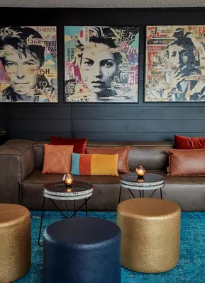 a lobby with a couch and tables and posters at Sir Adam Hotel, part of Sircle Collection in Amsterdam