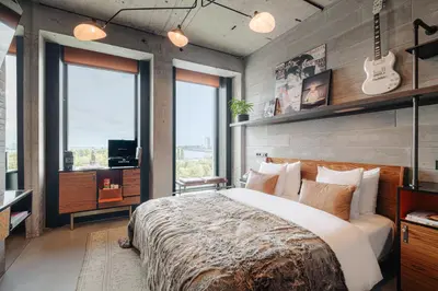 a bedroom with a large bed with a guitar on the wall at Sir Adam Hotel, part of Sircle Collection in Amsterdam