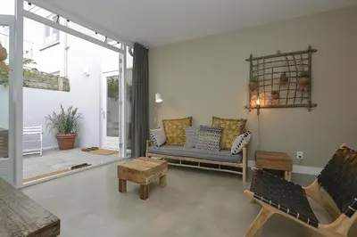 a living room with a couch and some chairs at Follow The Sun Apartment in Zandvoort