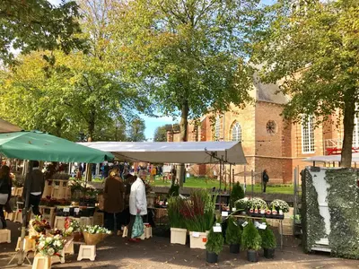 a farmers market in front of a brick building at Appartementen de Strandloper in Bergen aan Zee