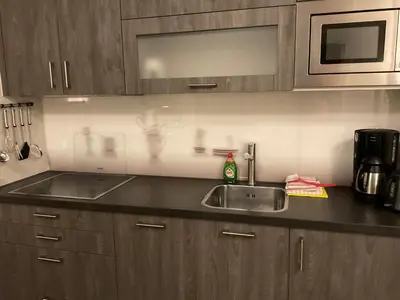 a kitchen with a sink and a microwave at Appartementen de Strandloper in Bergen aan Zee