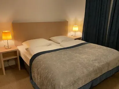 a bedroom with a large bed with two lamps on tables at Appartementen de Strandloper in Bergen aan Zee