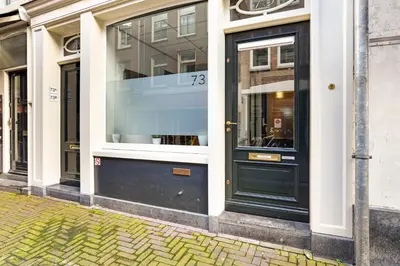a store front with a black door on a street at Only Friends in Amsterdam