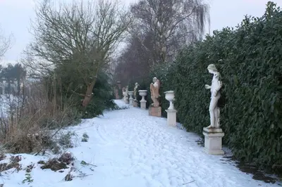 a row of statues on a snow covered path at Paradijs Eiland in Hillegom