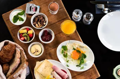 a table topped with plates of breakfast foods and orange juice at Vesting Hotel Naarden in Naarden
