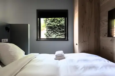 a white bed in a room with a window at Vesting Hotel Naarden in Naarden