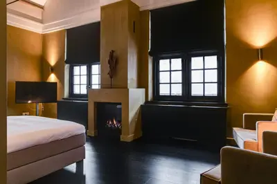 a bedroom with a bed and a fireplace at Vesting Hotel Naarden in Naarden