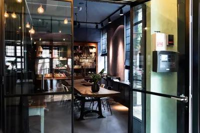 a restaurant with a table in a room with glass walls at Vesting Hotel Naarden in Naarden