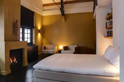 a bedroom with a bed and a fireplace at Vesting Hotel Naarden in Naarden