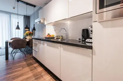 a kitchen with white cabinets and a dining table at YAYS Amsterdam North by Numa in Amsterdam