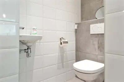 a bathroom with a toilet and a sink at Anne's Family Home with private parking in Zandvoort