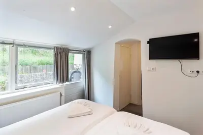 a bedroom with a bed and a flat screen tv at Anne's Family Home with private parking in Zandvoort