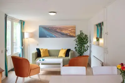 a living room with a couch and a table at Anne's Family Home with private parking in Zandvoort