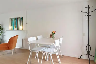 a white dining room with a white table and chairs at Anne's Family Home with private parking in Zandvoort