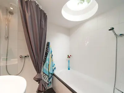 a bathroom with a shower and a bath tub at Holiday Home Bergen near Forest & Beach in Bergen