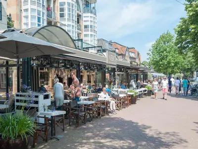a street with tables and chairs and people walking around at Holiday Home Bergen near Forest & Beach in Bergen