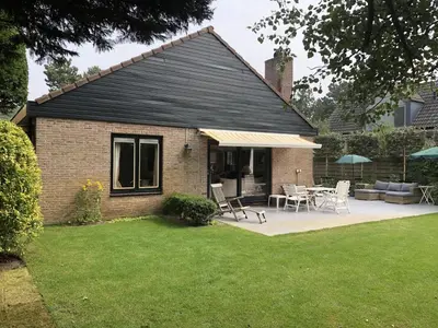 a house with a patio and a table and chairs at Holiday Home in Bergen aan Zee with Terrace in Bergen aan Zee