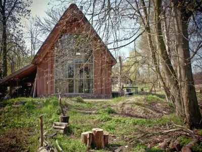 a house with a large window in the middle of a field at Holiday Home in Bergen near Forests in Bergen