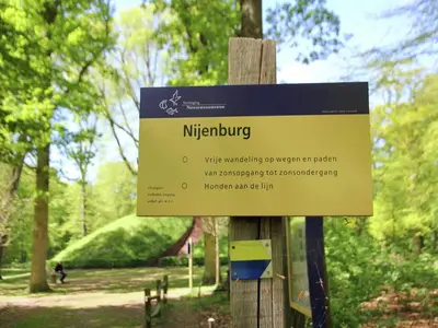 a sign on a wooden pole in a park at Apartment in Heiloo near North Sea Beach in Heiloo