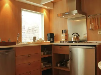 a kitchen with a stainless steel refrigerator and a window at Apartment in Heiloo near North Sea Beach in Heiloo